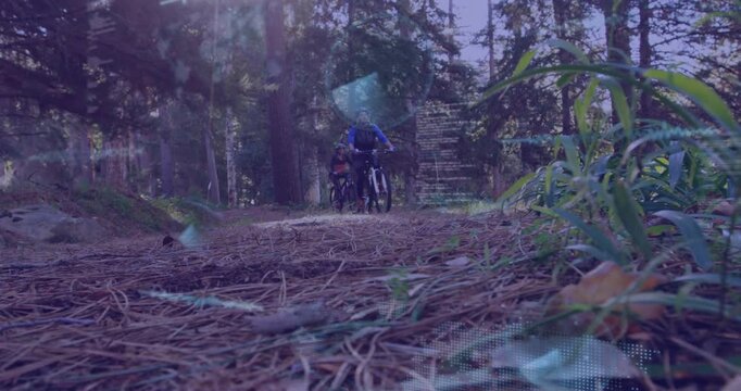 Cyclists pushing bikes on pine trail activating fitness data with woman lagging behind man emerging