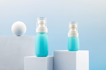 a set of unbranded bottles of cream, lotion or other cosmetics on a catwalk on a blue gradient background.