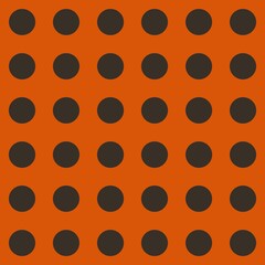 A grid of evenly spaced black dots is set against an orange background. The pattern creates a uniform and symmetrical appearance.