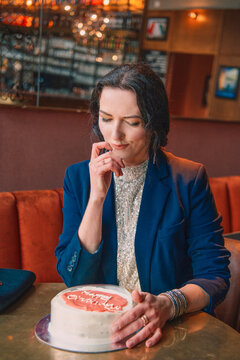 Smiling woman holding a birthday cake with a sparkler