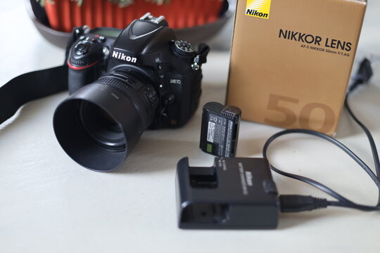 Copenhagen, Denmark - August 31, 2021: Nikon D610 camera with 50mm f1.4G lens box and battery charger on a table