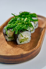 Deliciously Crafted Sushi Rolls Featuring Fresh Ingredients Topped with Vibrant Seaweed on a Natural Wooden Plate for a Culinary Delight
