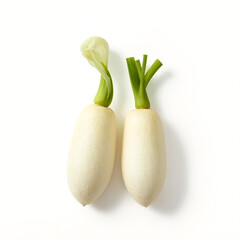 Two cylindrical white daikon radishes with vibrant green tops are positioned side by side against a stark white backdrop