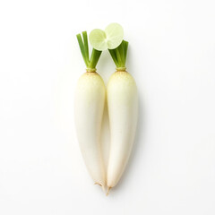 A top-down view of two elongated white daikon radishes with vibrant green leafy tops isolated on white