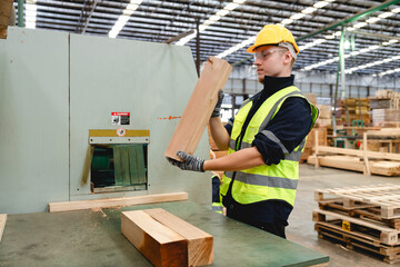Worker in yellow helmet using sawmill equipment to shape timber blocks, contributing to efficient material flow in pallet manufacturing and supply chain operations.
