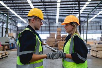 Smiling timber factory colleagues are shaking hands after finalizing work plan, highlighting teamwork, trust and communication in industrial supply chain environment.