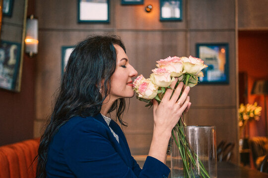 Smiling woman with flowers in a cafe, black and white portrait
