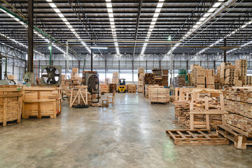 Interior of large timber pallet warehouse showing stacked wood planks and crates. Spacious layout designed for organizing goods for cargo distribution and export logistics.
