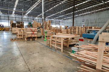 Empty center aisle inside lumber storage facility with stacked pallets and wooden packaging crates....