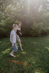 Fototapeta premium A mother and her son with hearing aids launch a paper airplane in a park, a heartwarming moment of inclusive play and bonding in nature. Perfect for disability awareness and family lifestyle content