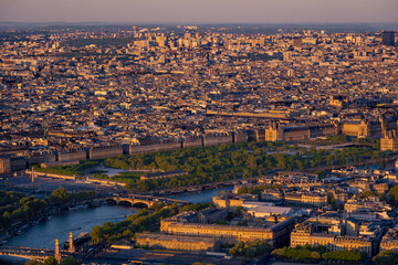 Panoramic aerial view of a wide Parisian cityscape with the Tuileries Garden and the Louvre Palace at the golden hour at sunset, stretching to the horizon. Paris, France.