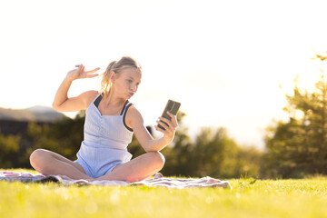 Young cheerful smiling girl using smartphone for communication and video chat. Woman taking selfie...