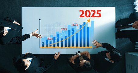 A high-angle view of a business meeting featuring professionals gathered around a table discussing...