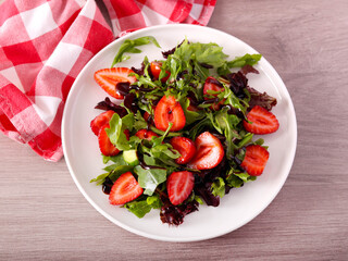Green salad with strawberry and balsamic on plate