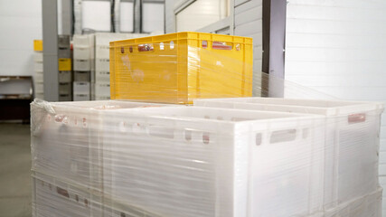 Plastic crates wrapped in stretch film in warehouse