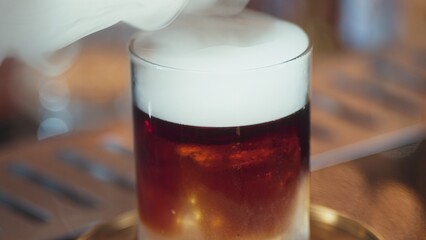Focusing serving mist smoky classical in Old fashioned of whiskey cocktail presentation on bokeh background recommending special welcome tasty creative advertisement drink at beverage bar. Vinosity.