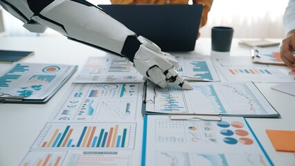 A robotic hand interacts with various business data sheets in a modern office, showcasing the...