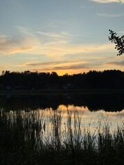 sunset over lake with reeds and clouds