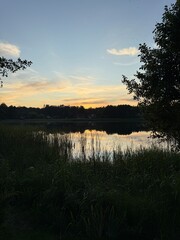 sunset over a lake with reeds and reflections 