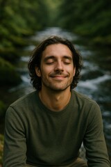A happy, handsome man smiling peacefully with eyes closed in a serene natural setting