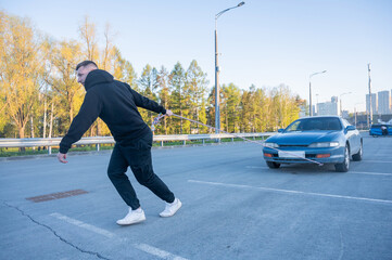 Caucasian man pulling a car with a rope. 