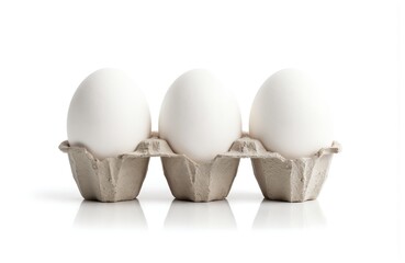 White eggs of equal size in carton against bright white background. Eggs glossy smooth surface, white interiors contrast stark whiteness. Clean, isolated, food, kitchen, freshness, organic, protein,