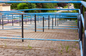 Worn blue handrails along brick ramp structure
