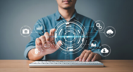 Man using futuristic digital interface on keyboard with technology icons representing data analytics automation cloud computing and business process management

