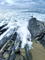 Landscape. The shoreline. Waves and ocean foam. Rocks. View from above. Texture background. Postcard. Poster.