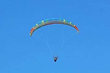 Paraglider flying in a blue sky	