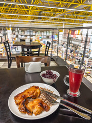 Modern canteen dining scene with caramelized chicken stewed buckwheat grains crisp beetroot relish and chilled red berry kompot glass