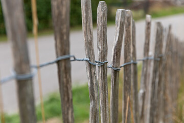 Fototapeta premium Close-up of rustic wooden stake fence with wire detail