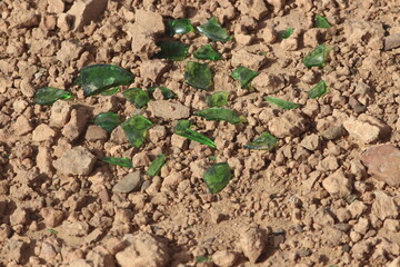 Green glass shards on the ground