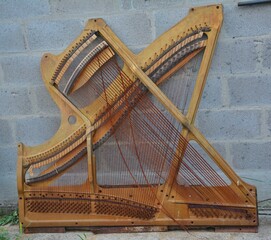 Broken harp piano interior with visible strings. Interior mechanics of a broken piano harp exposed. Ideal for music concepts, instrument repair themes, or educational materials on sound st