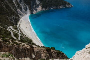 Famous Myrtos Beach viewed from above showing turquoise waters white sand and winding access road