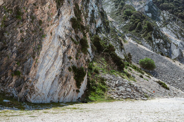 Close-up of weathered limestone cliff formations with natural erosion patterns at beach level