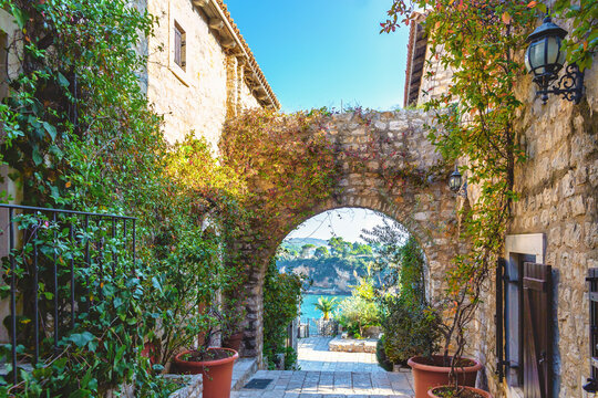 Charming stone alley with arch and sea view in Ulcinj Old Town on sunny day, Montenegro