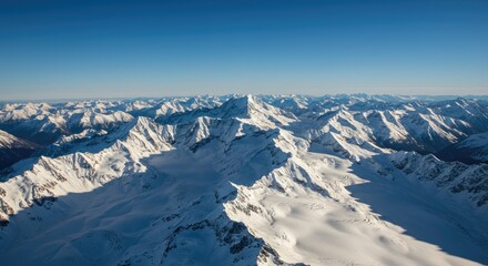 Naklejka premium Majestic Snow-Capped Mountain Range Under Clear Blue Sky, Aerial View