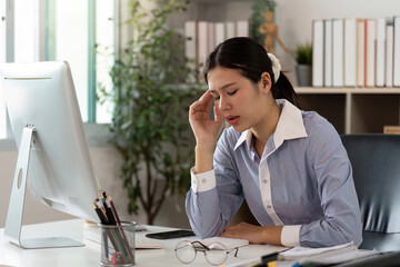Office Syndrome: Young woman experiencing stress and headache at her desk