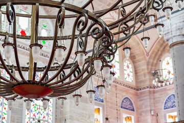 Close-up of metal chandelier with frosted lamps in Mihrimah Sultan Mosque interior, Istanbul, Turkey