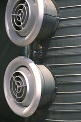 Vertical close-up of industrial ventilation and climate control system with circular air ducts at...