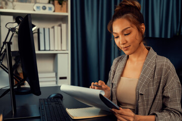 Businesswoman focusing on paperwork folder file on working desk, analyzing market planning database...