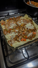 Vertical photo of a delicious and juicy lasagna, ground beef with pasta and red sauce, homemade.