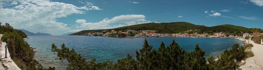 Sweeping panoramic view of Kefalonia's coastline with traditional villages and forested hills.