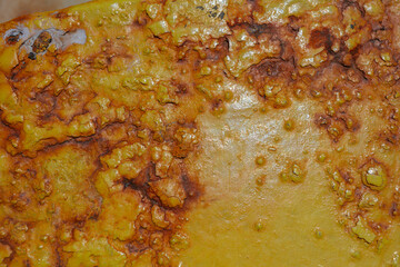 Weathered yellow boat mooring bollard on stone dock beside Mediterranean harbor waters.