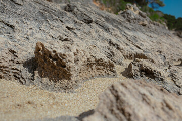 Natural limestone rock formations with golden sand creating Mediterranean coastal landscape patterns