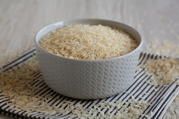Uncooked White Organic Basmati Rice in a Bowl, side view. Close-up.