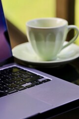 Praca z domu filiżanka i komputer na stole. Praca i biznesowy klimat. Zdalna praca w domu.