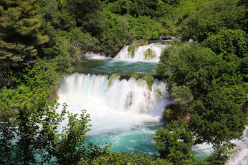 A cascade waterfall among large stones in Krka Park, Croatia, The best big beautiful Croatian waterfalls, mountains and nature.