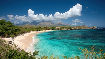 Turquoise bay meets sandy beach; mountains rise under a blue, cloudy sky